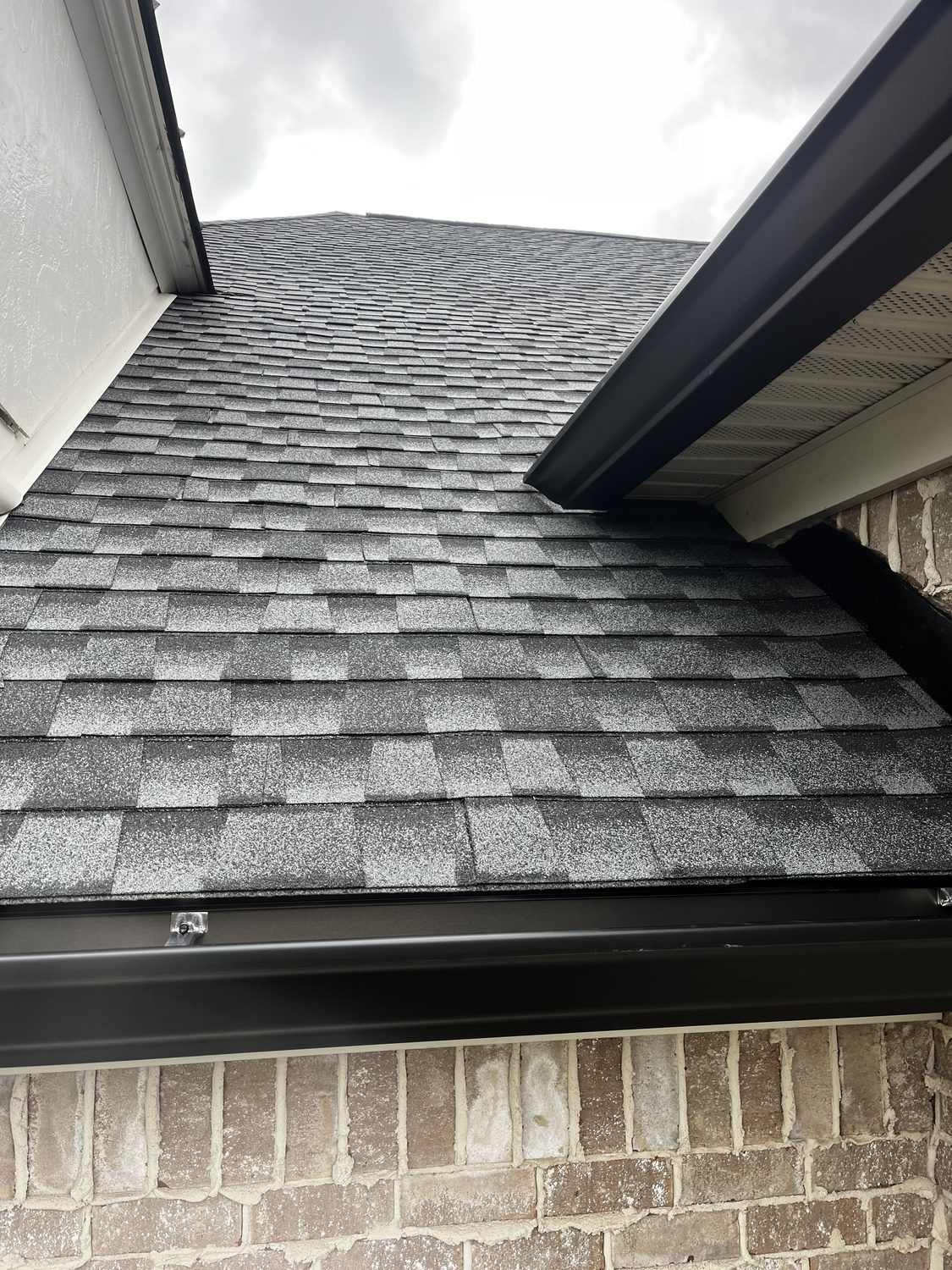 Dark seamless gutter run along the roofline by Gutter And Covers, Cookeville