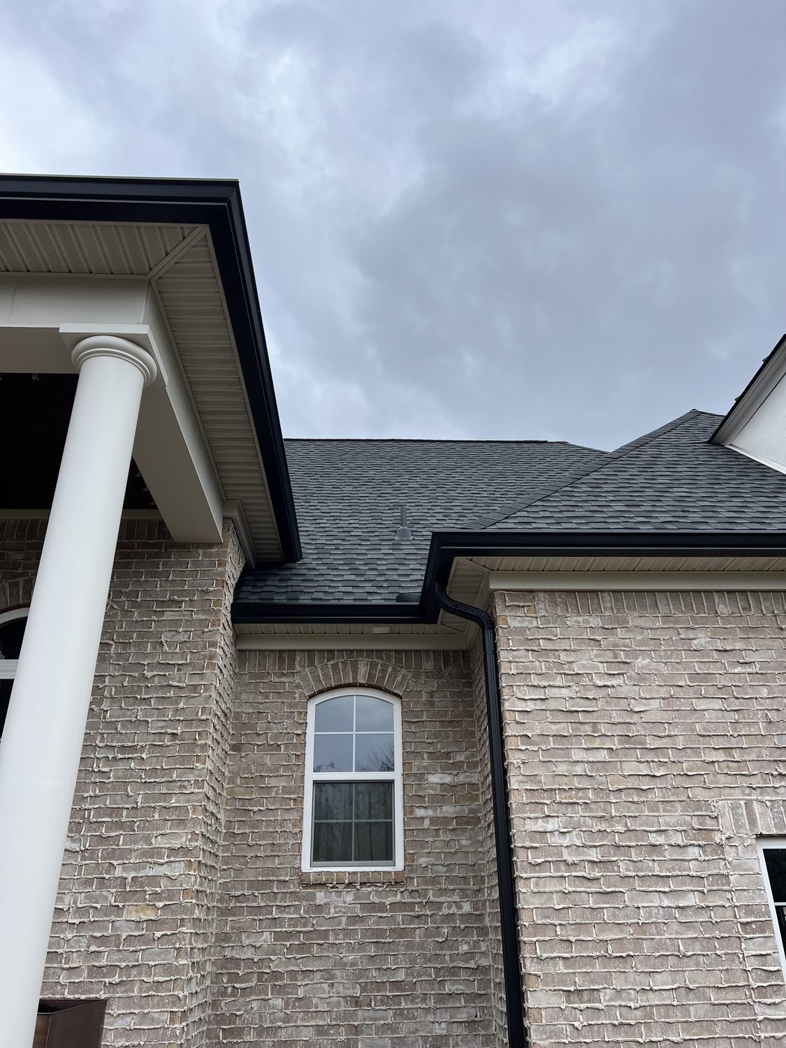 Gutter and downspout beside a covered porch by Gutter And Covers, Cookeville