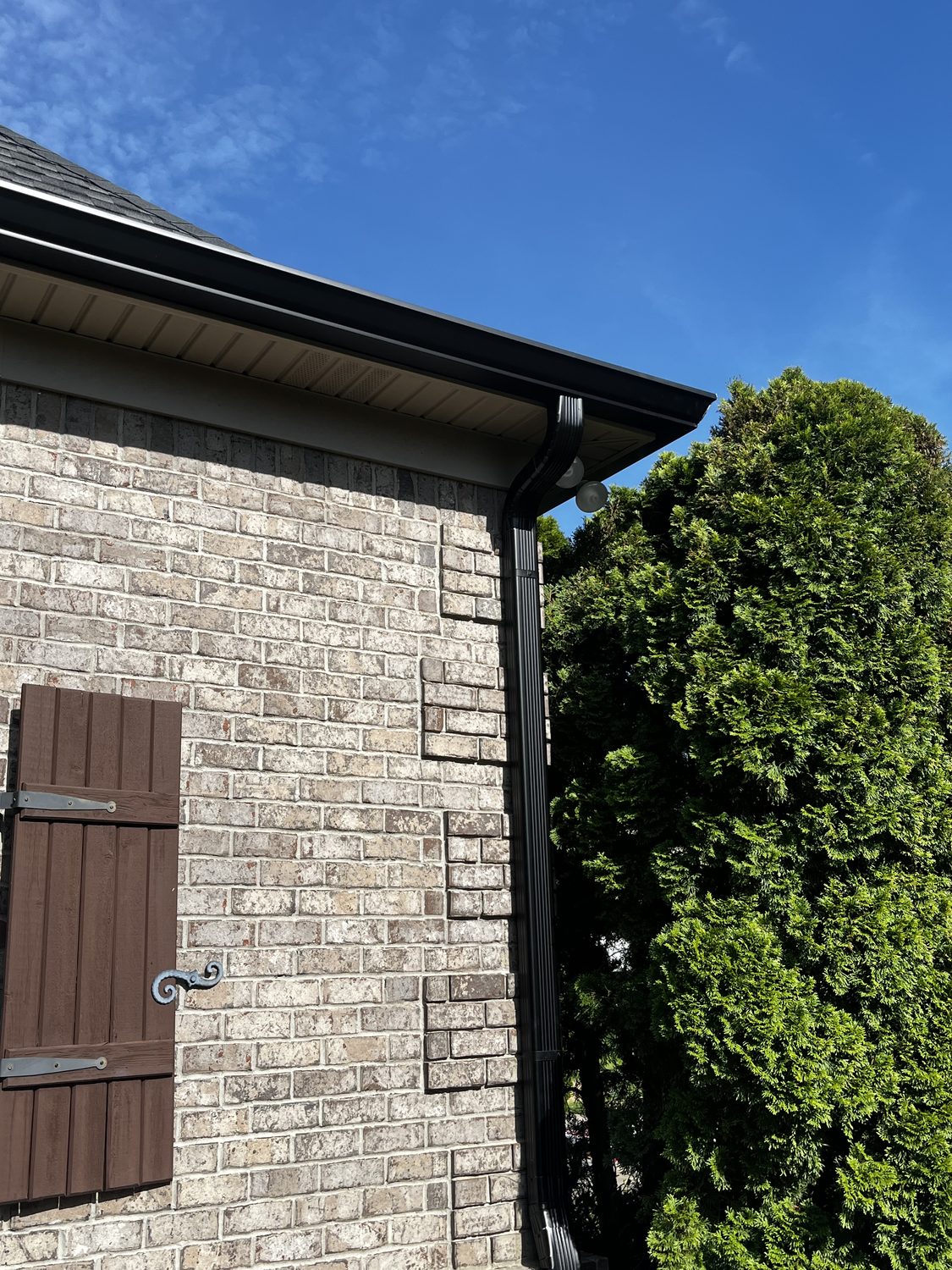 Gutter corner and downspout on a brick exterior by Gutter And Covers, Cookeville