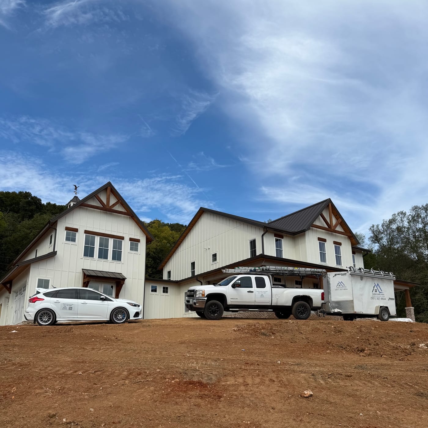 Truck and trailer on site at a farmhouse new build by Gutter And Covers, Cookeville